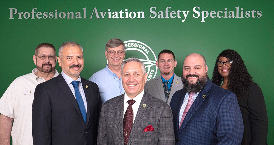 The seven members of the PASS Executive Board against a green background with PASS logo.